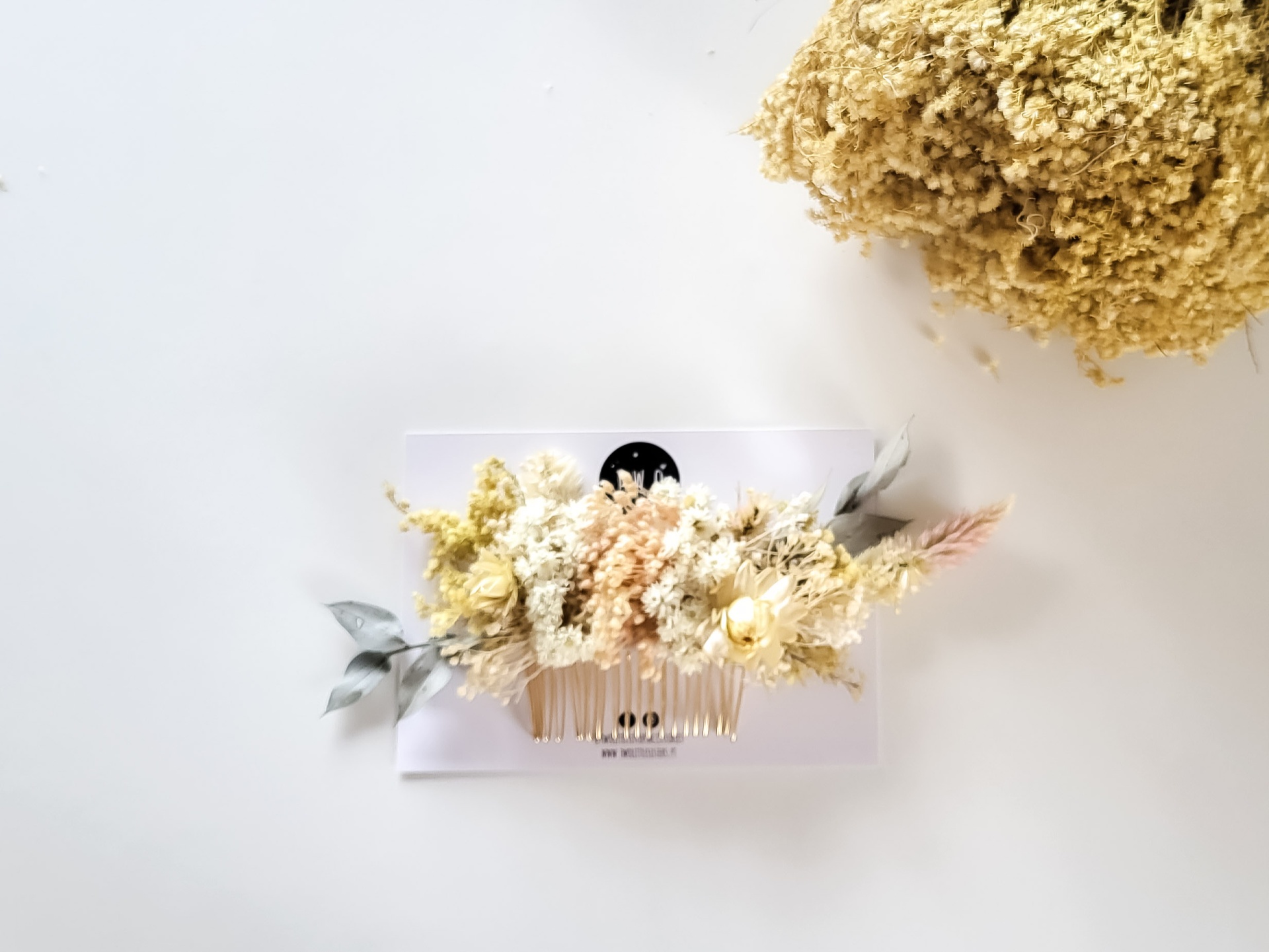 Pente decorativo com flores secas artificiais em cartão transparente sobre fundo branco