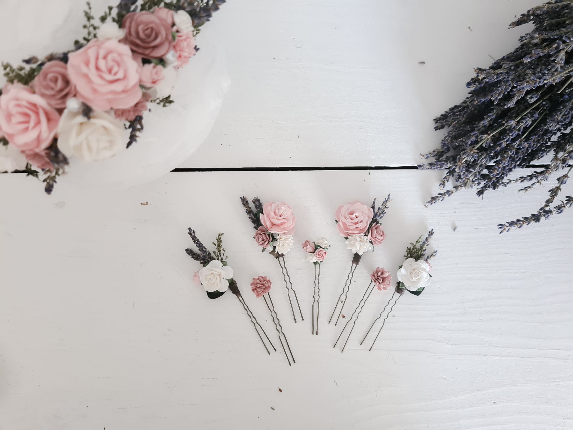 Pentes para cabelo com flores rosa e brancas sobre superfície branca