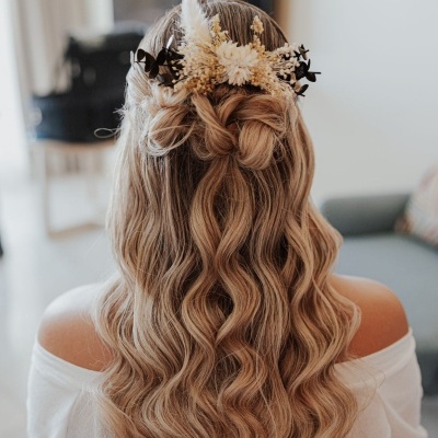 Cabelo longo e ondulado preso com acessório floral de flores secas