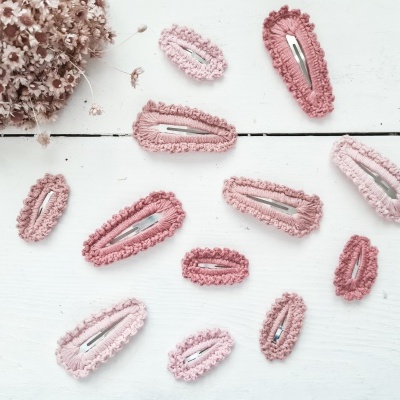 Molas de cabelo rosas felpudas e flores secas sobre fundo branco