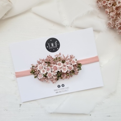 Faixa de cabelo rosa com flores de tecido sobre cartolina branca com logótipo