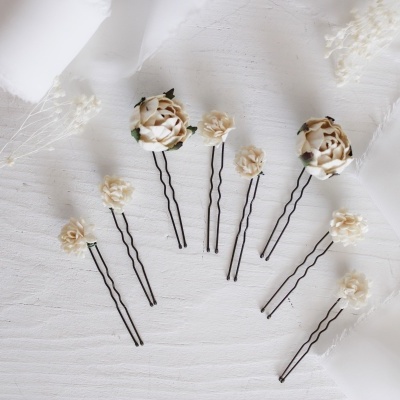 Ganchos de cabelo com flores artificiais castanhas e bege sobre fundo branco