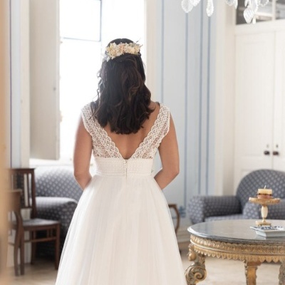 Vestido de noiva branco de costas com corpete de renda e saia fluida em ambiente clássico