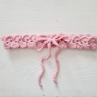 Faixa de croché cor-de-rosa com padrão ondulado