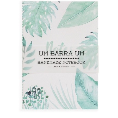 Caderno artesanal com padrão de folhas em tons verdes e faixa com texto