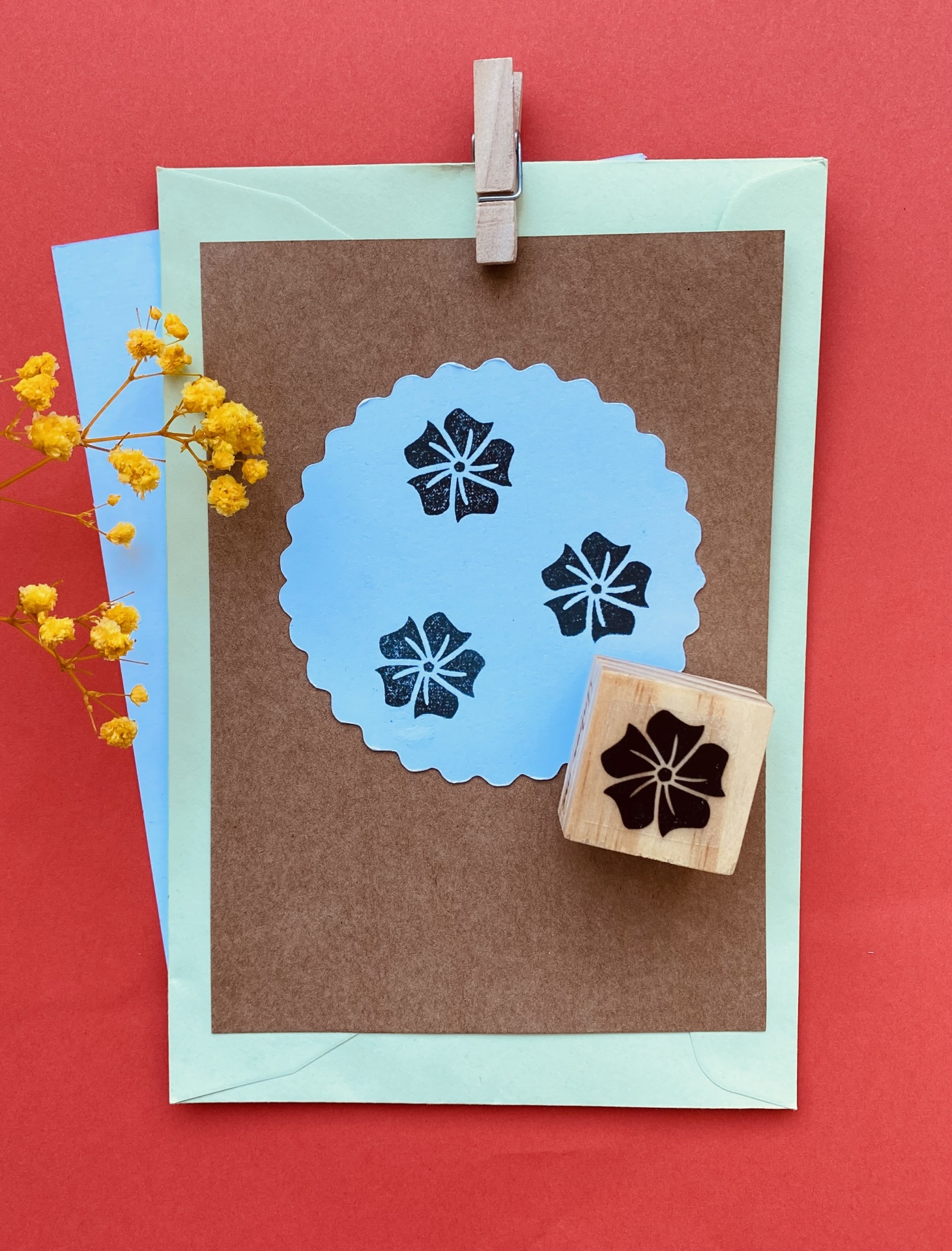 Cartões de papel com carimbos de flores e envelopes sobre fundo vermelho
