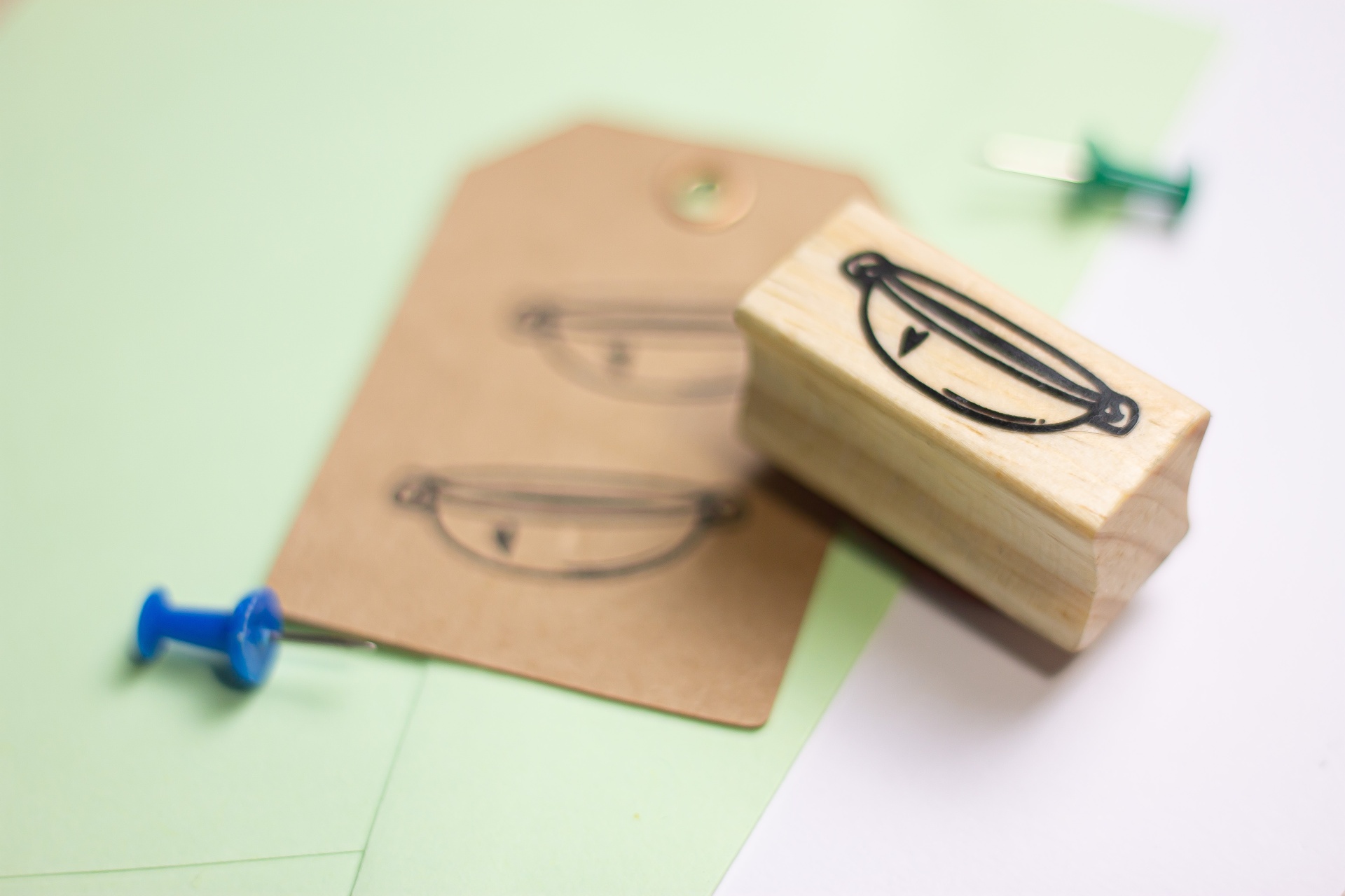 Carimbo de madeira com desenho de panela e etiqueta carimbada sobre papel verde