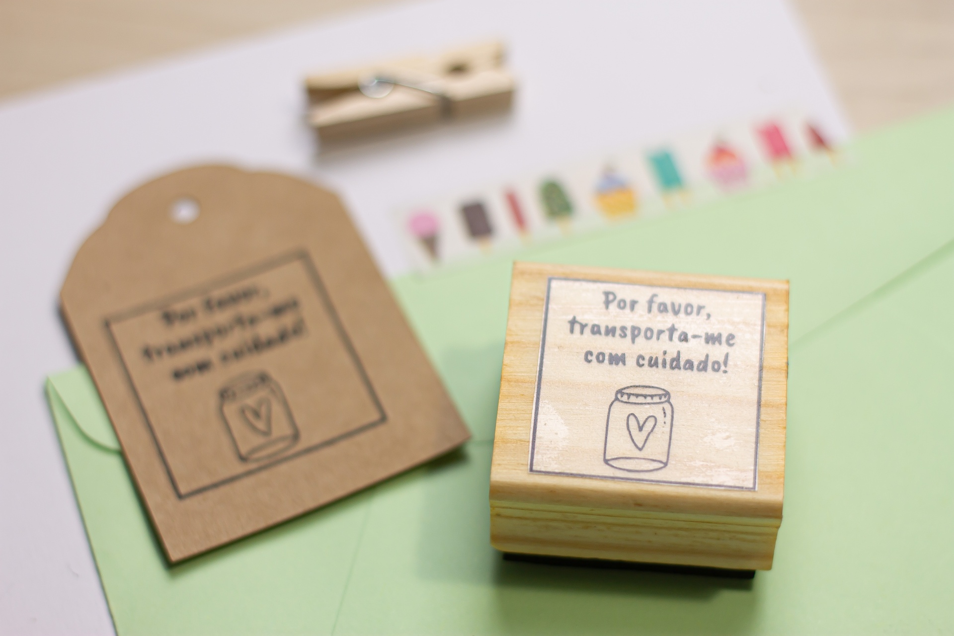 Carimbo de madeira com pedido de cuidado e etiqueta similar sobre envelopes e prendedor