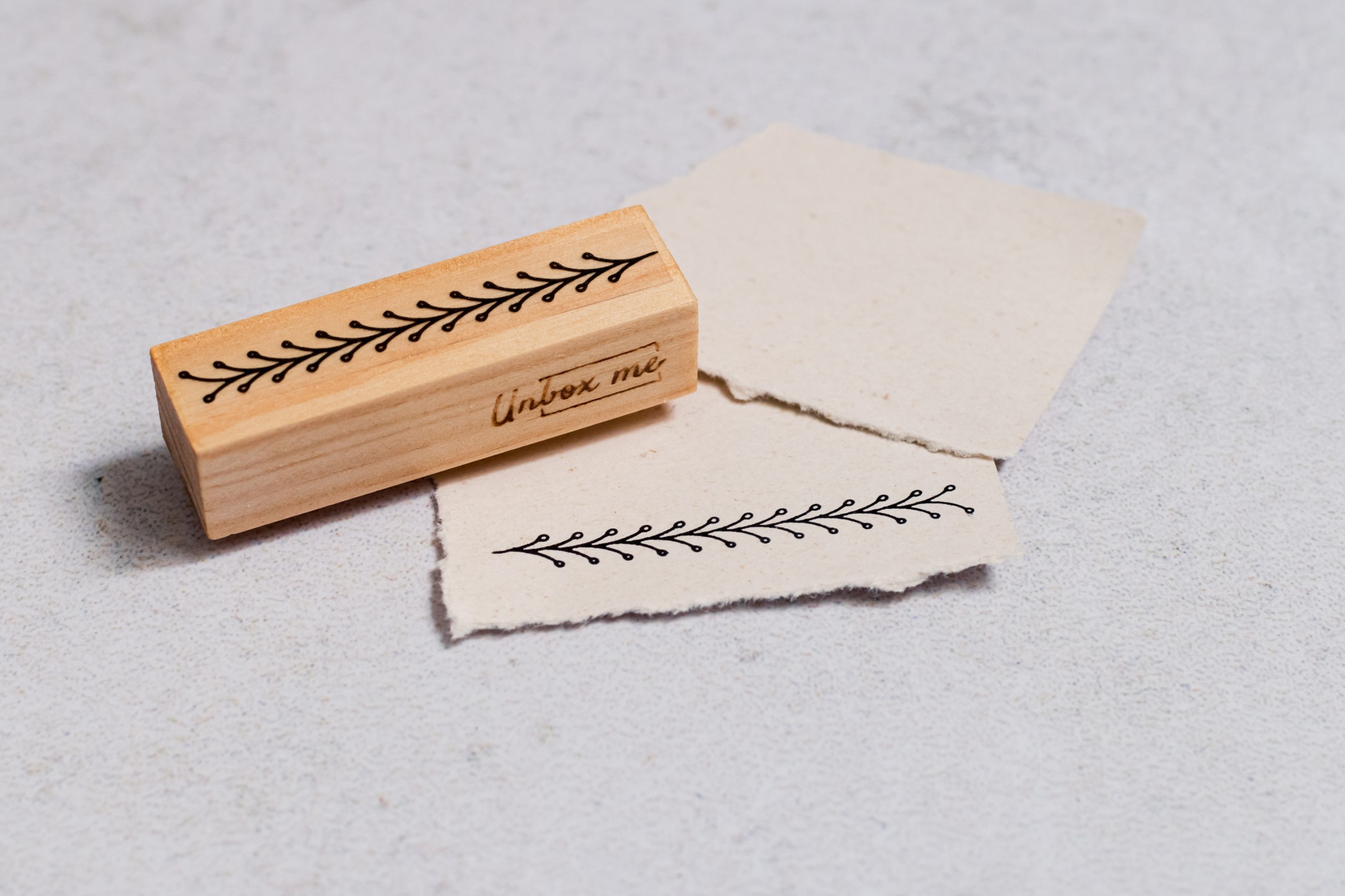 Carimbo de madeira com padrão de ramo e pedaço de papel carimbado