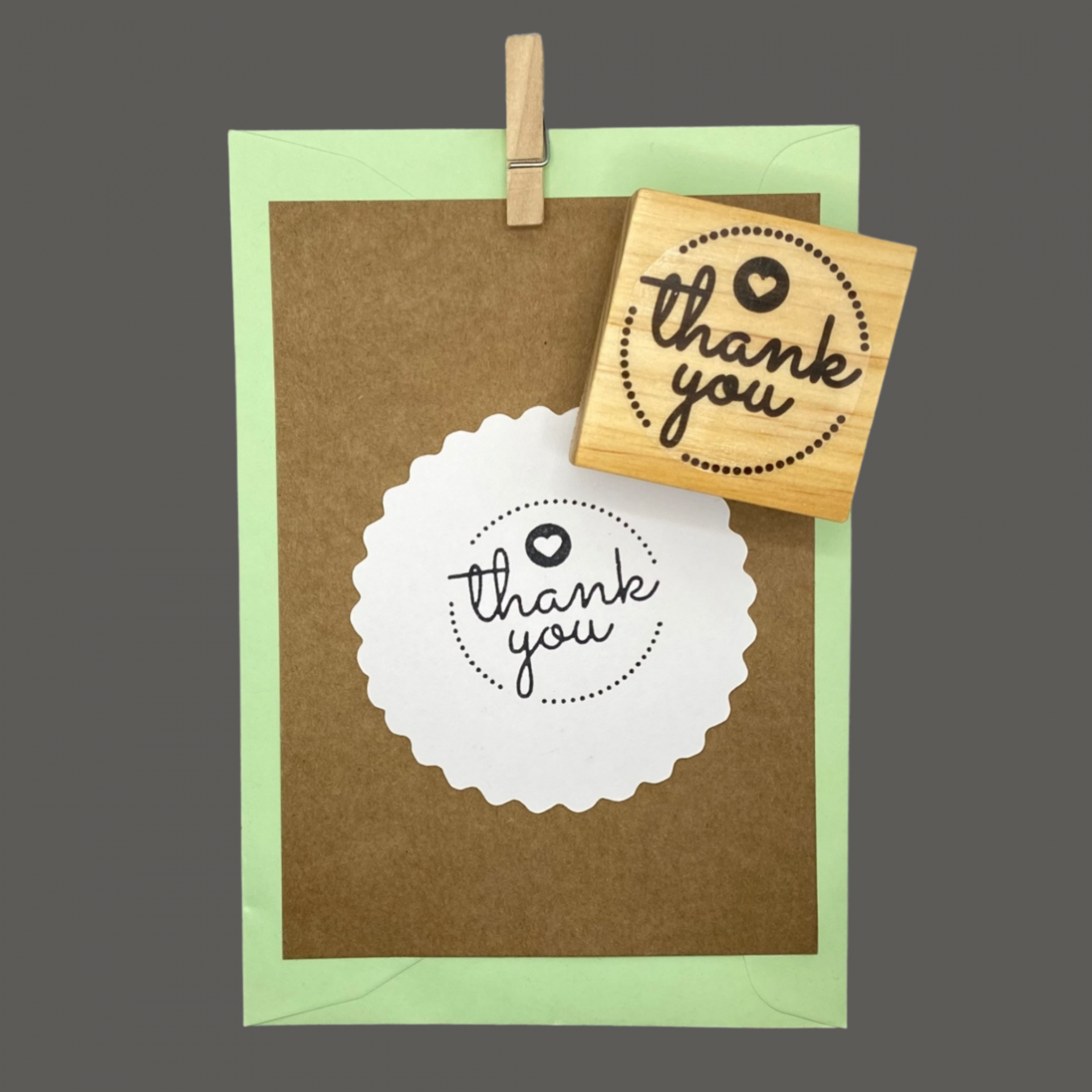 Carimbo de madeira com texto thank you sobre cartão e envelope