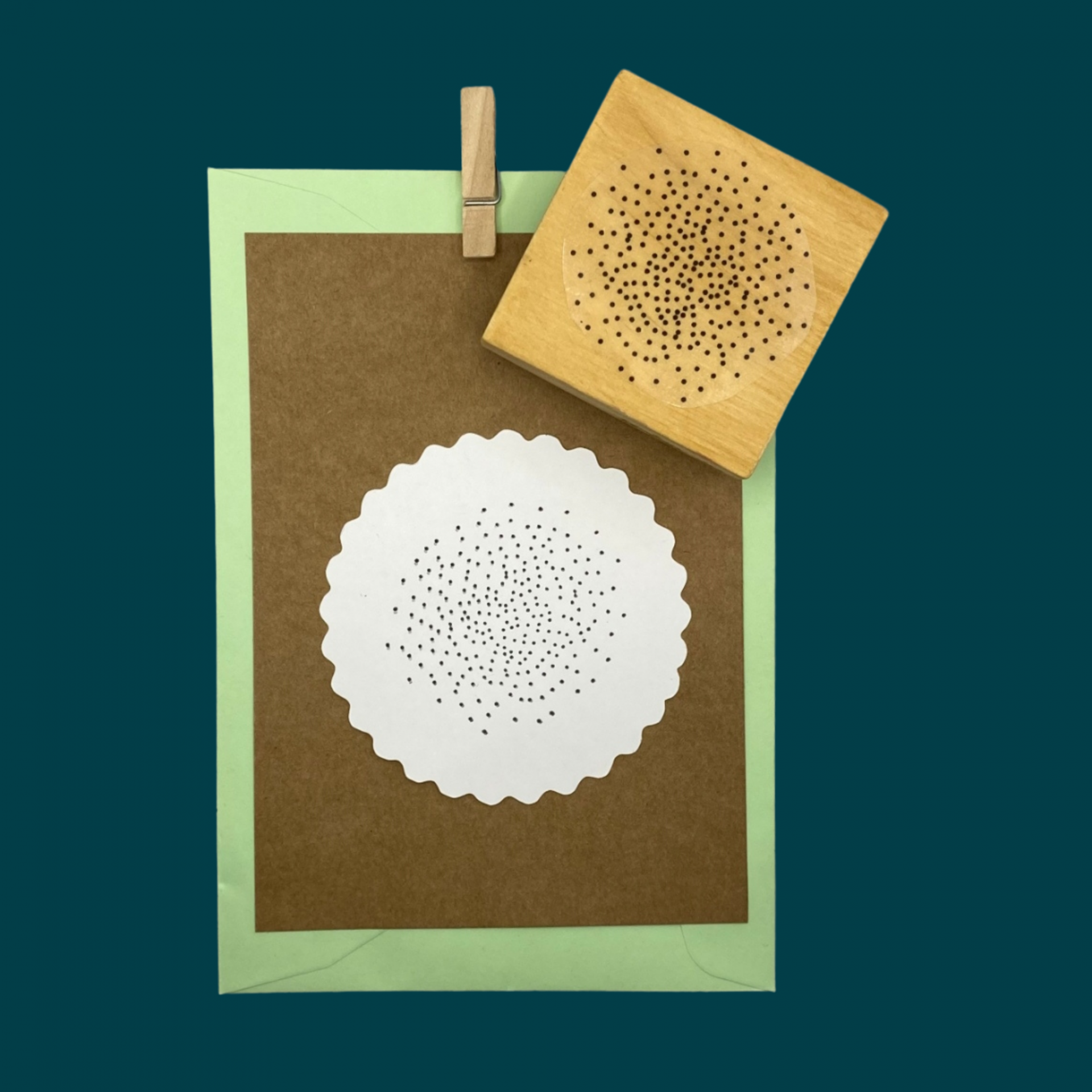 Carimbo de madeira quadrado com padrão de pontos, papel marron com impressão branca circular recortada,Envelope verde e prendedor de madeira