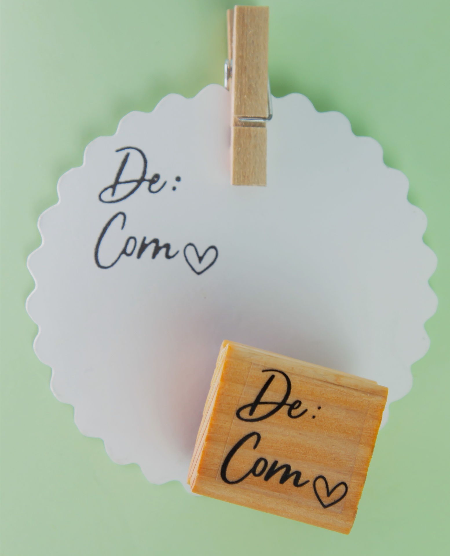 Carimbo de madeira com texto e papel recortado branco com pregador de madeira