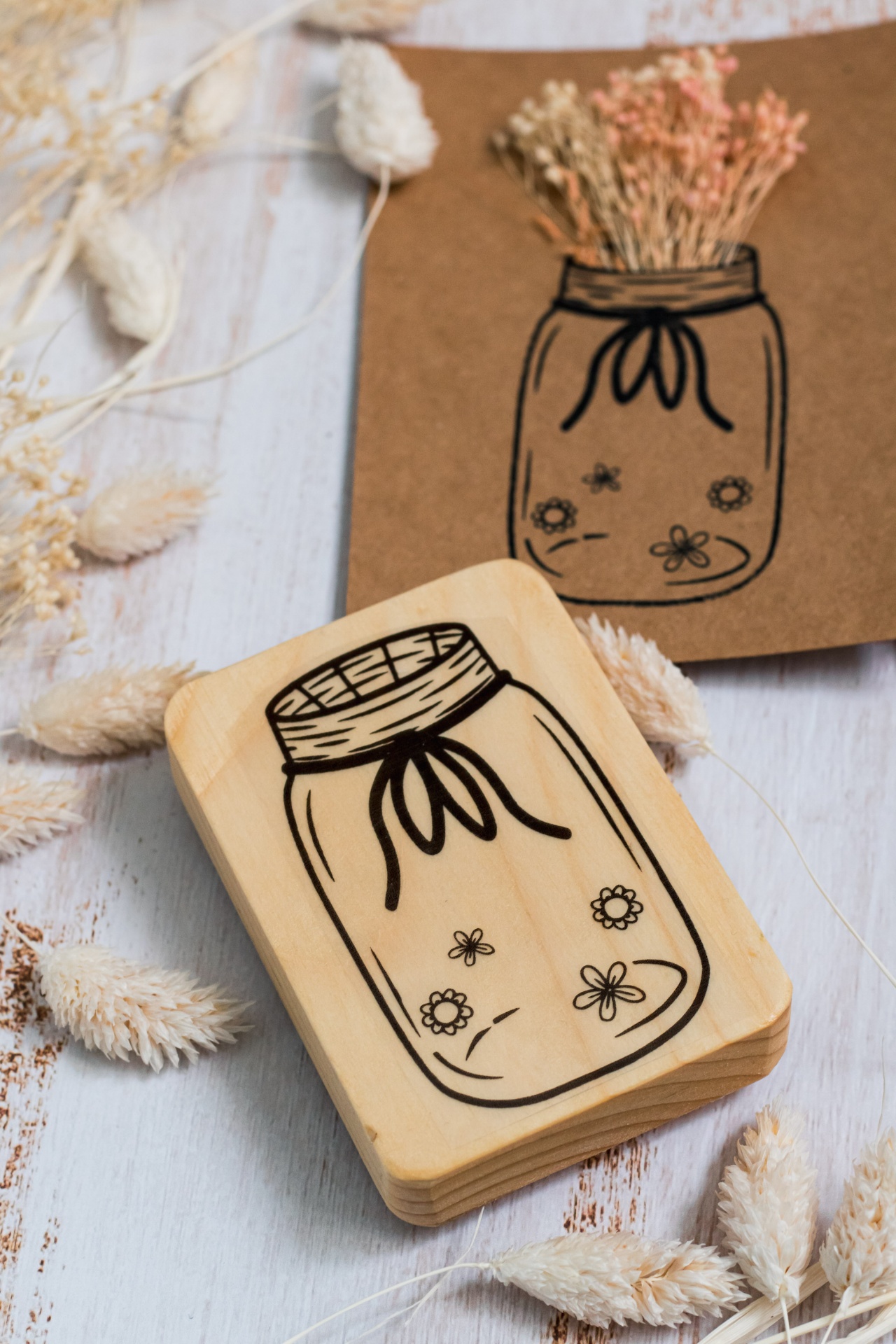 Carimbo de madeira com desenho de frasco floral e cartão castanho com desenho similar