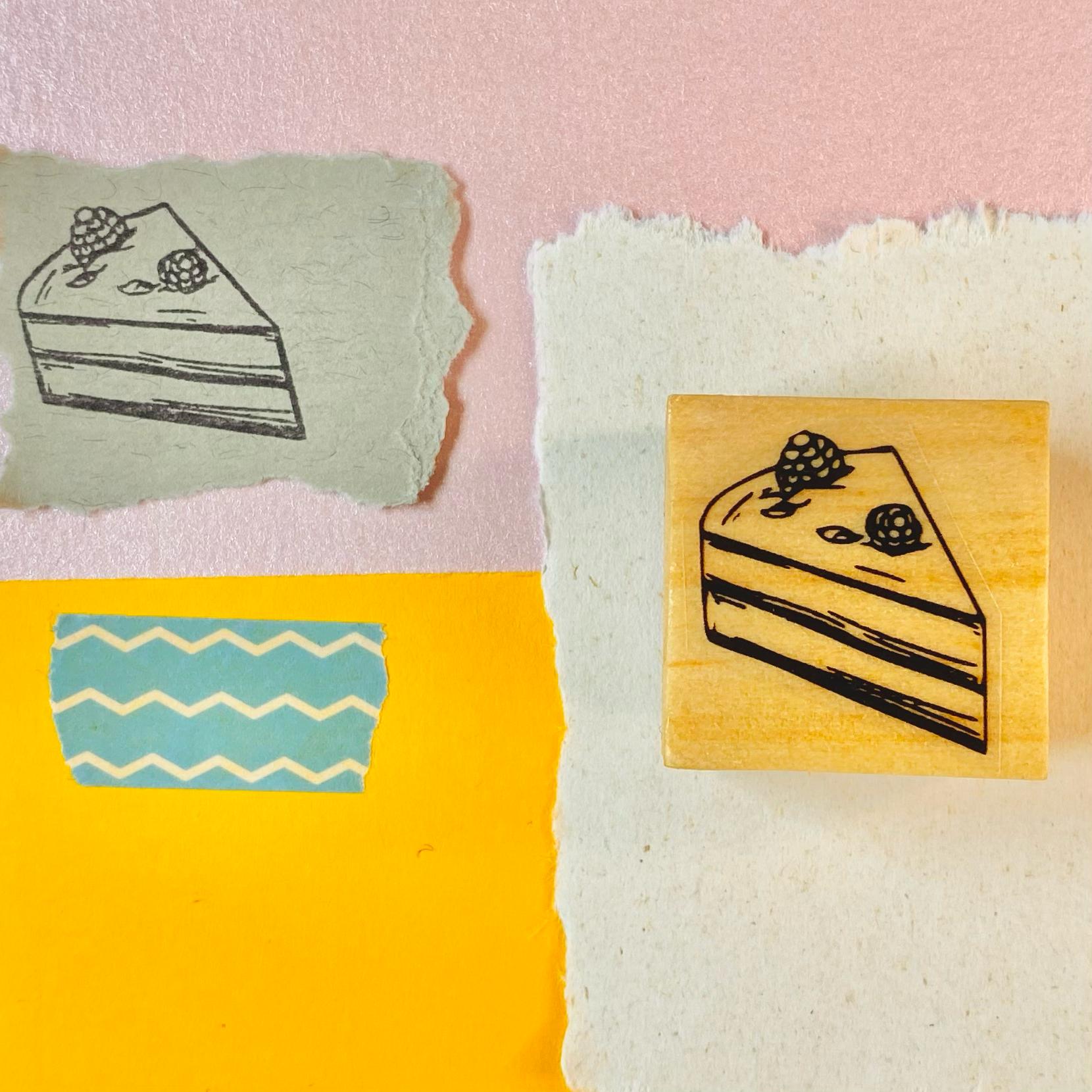 Carimbo de madeira com desenho de fatia de bolo e exemplo carimbado em papel