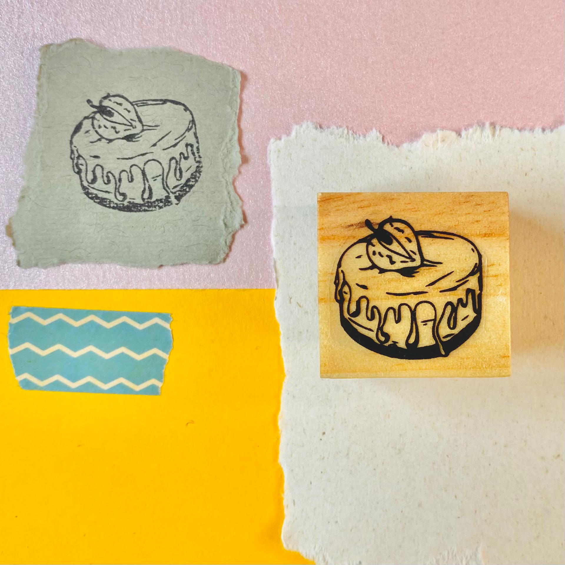 Carimbo de bolo em madeira com desenho de bolo com cobertura e fruto em papel decorativo colorido