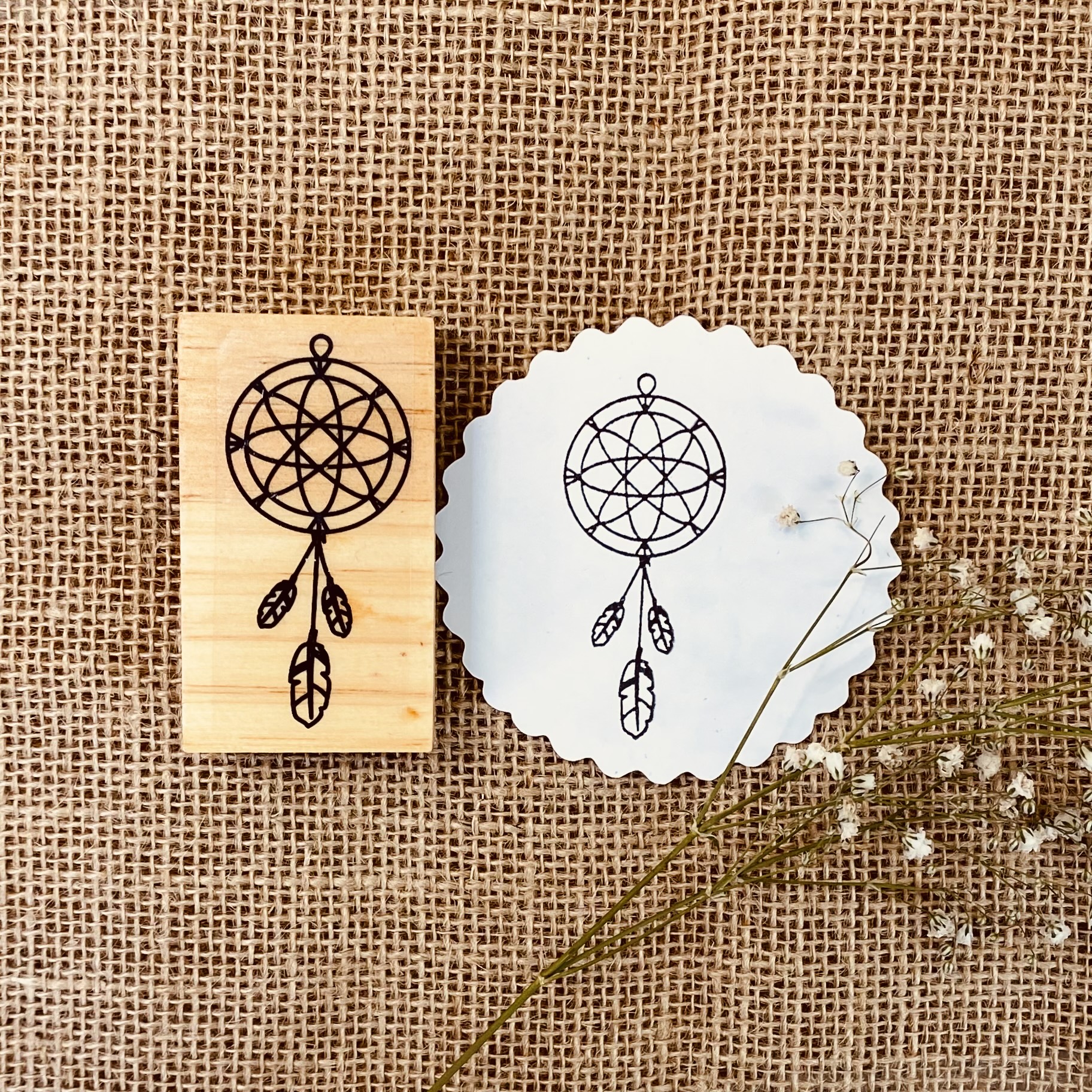 Carimbo de madeira com desenho de apanhador de sonhos e impressão correspondente em papel branco