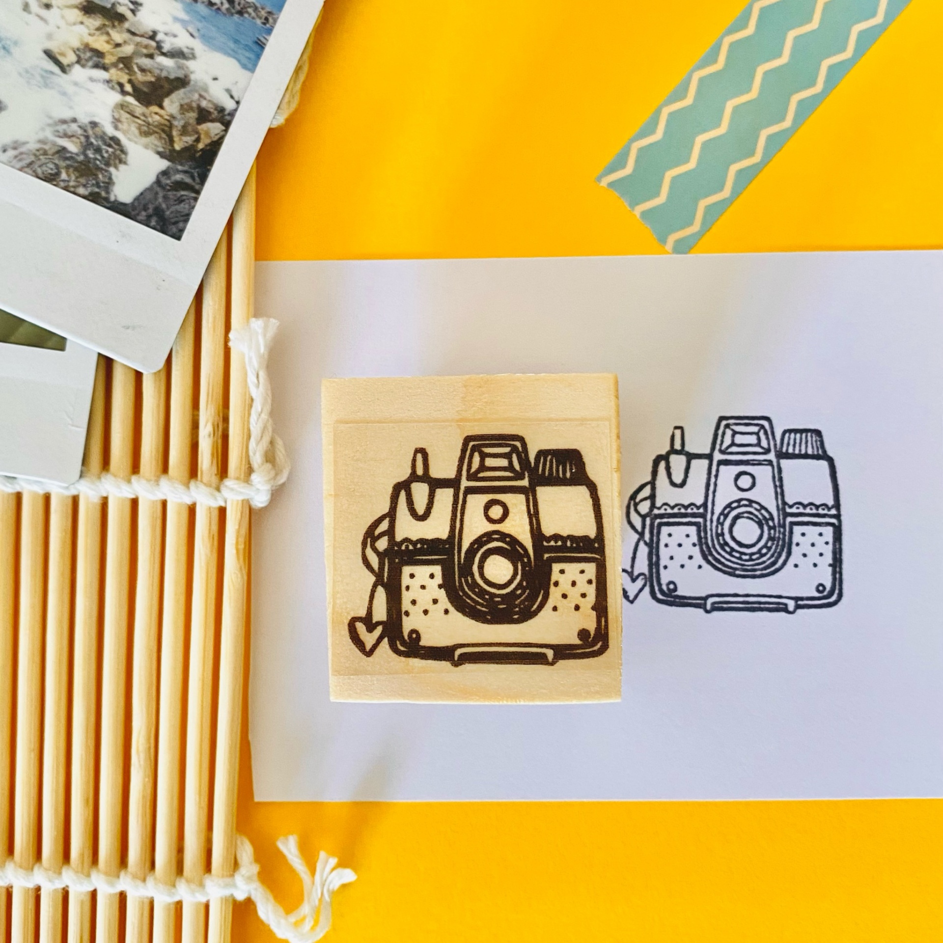 Carimbo de madeira com desenho de máquina fotográfica vintage na tinta preta sobre papel branco