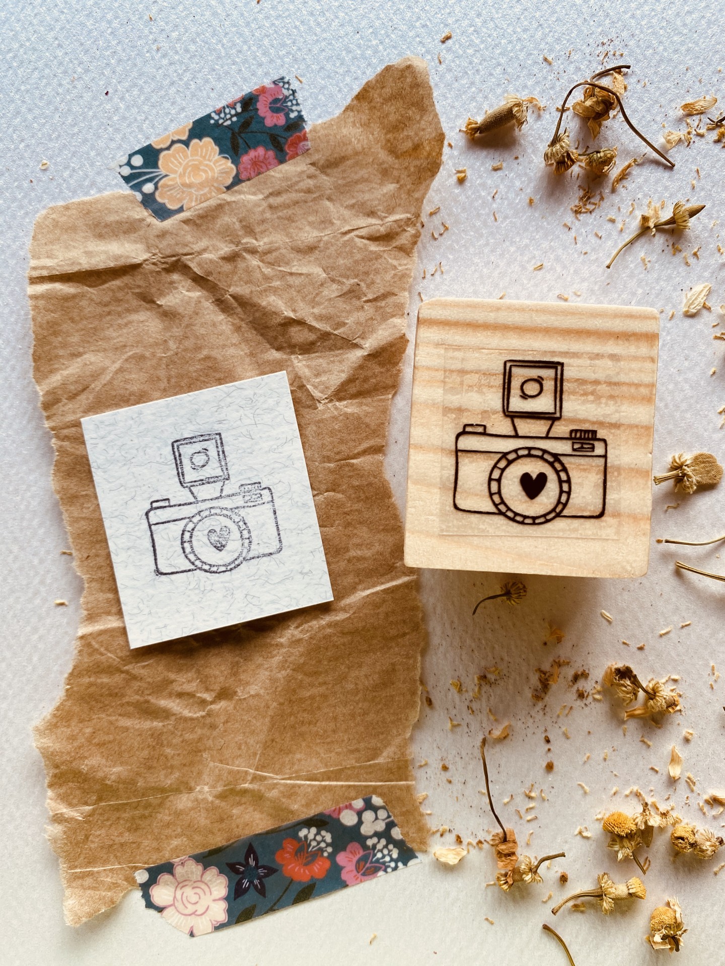 Carimbo de madeira com desenho de câmara fotográfica e impressão no papel