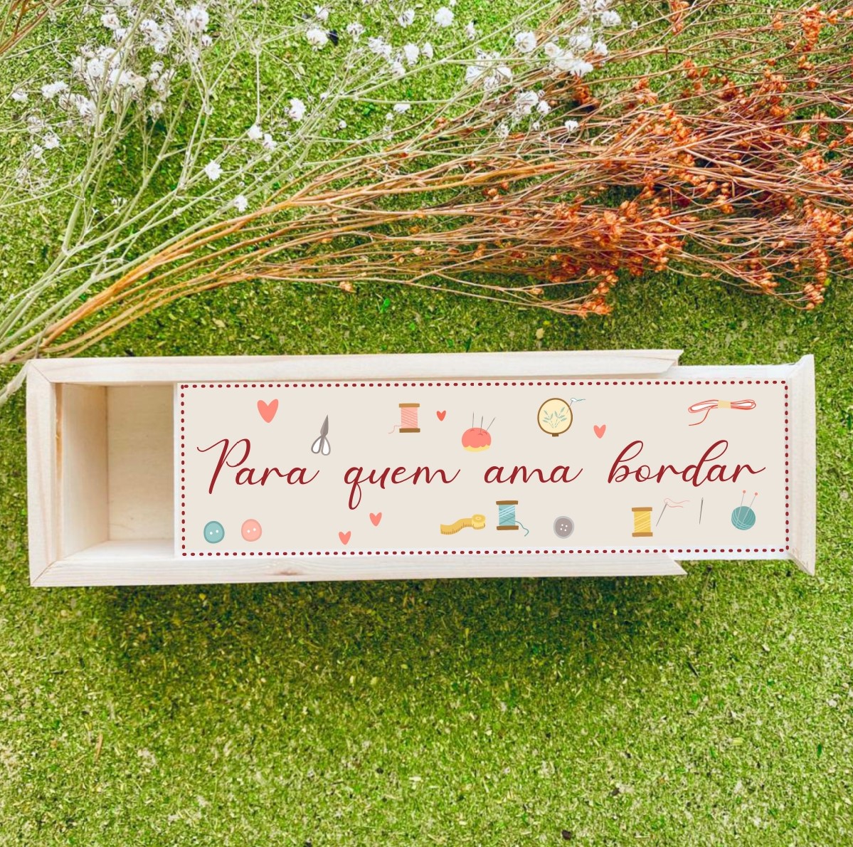 Caixa de madeira decorada com temática de bordado sobre relva