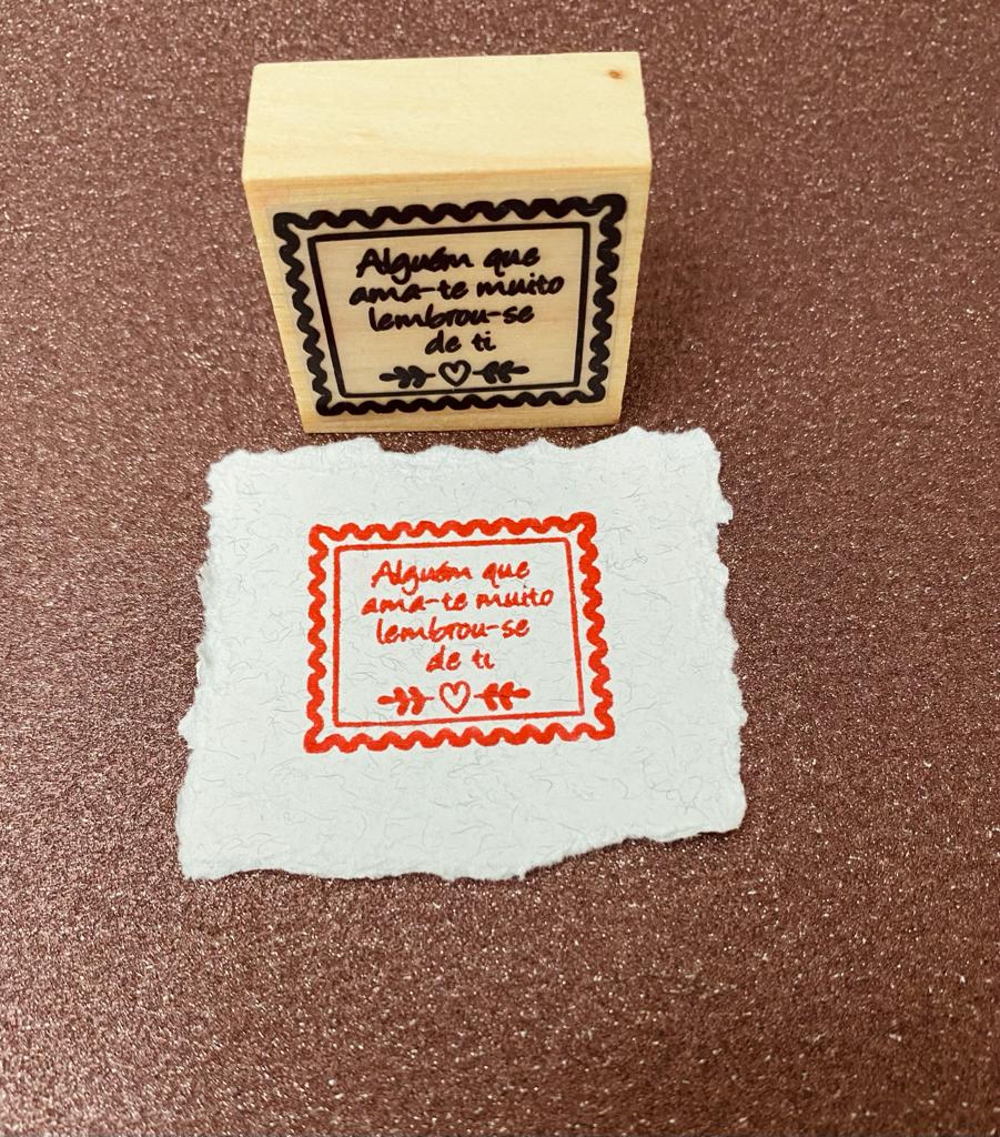 Selo de madeira com frase e impressão em papel branco