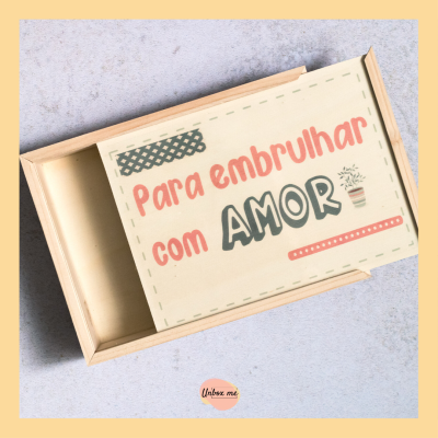Caixa de madeira clara com texto 'Para embrulhar com AMOR' e desenho de planta