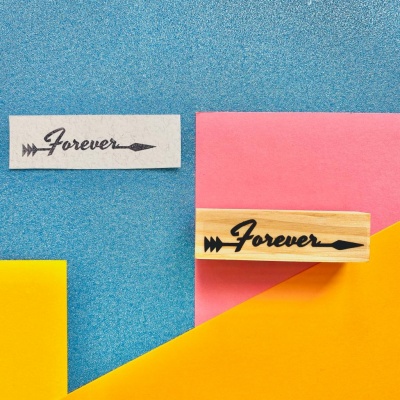 Carimbo de borracha com texto Forever e seta sobre fundo azul e cartas coloridas