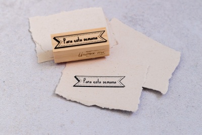 Carimbo de madeira com a frase Para esta semana sobre papel branco texturizado
