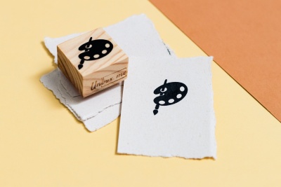 Carimbo de madeira e papéis com impressão de paleta de pintor e pincel