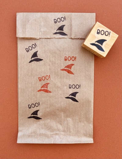 Saco de papel castanho com estampas de chapéu de bruxa e palavra BOO