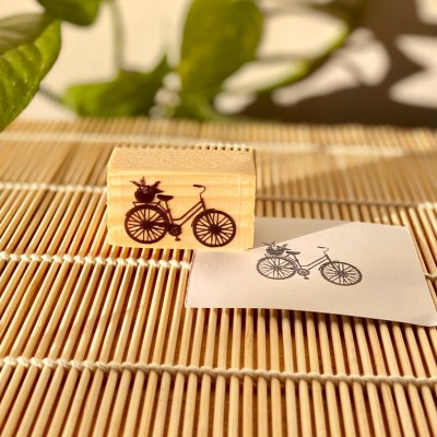 Carimbo de madeira com desenho de bicicleta e papel com impressão do desenho