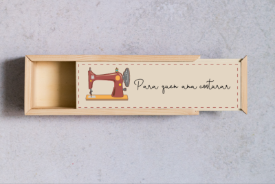 Caixa de madeira com desenho de máquina de costura e texto 'Para quem ama costurar' na tampa