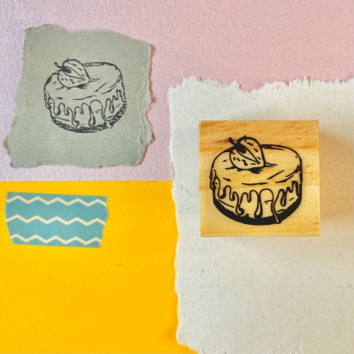 Carimbo de bolo em madeira com desenho de bolo com cobertura e fruto em papel decorativo colorido