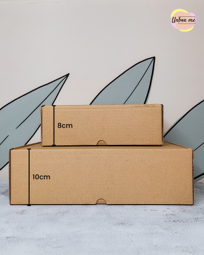 Duas caixas de cartão castanho empilhadas com fundo decorativo e logo Unbox me