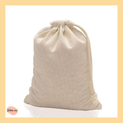 Saco de tecido bege com cordão de fecho em fundo bege claro