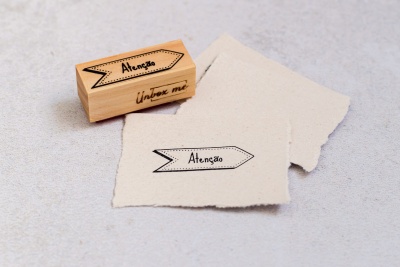 Carimbo de madeira com impressão 'Atenção' e papel carimbado