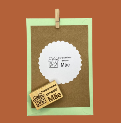 Carimbo e impressão com frase dedicada à mãe sobre papéis castanhos e verde claro