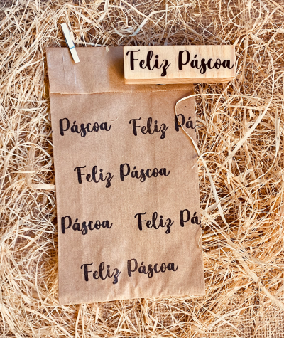 Saco de papel com a frase Feliz Páscoa em preto e carimbo de madeira