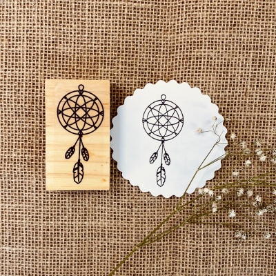 Carimbo de madeira com desenho de apanhador de sonhos e impressão correspondente em papel branco