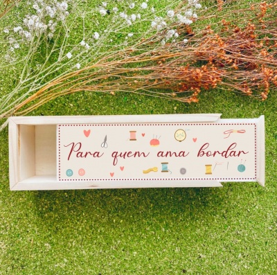 Caixa de madeira decorada com temática de bordado sobre relva