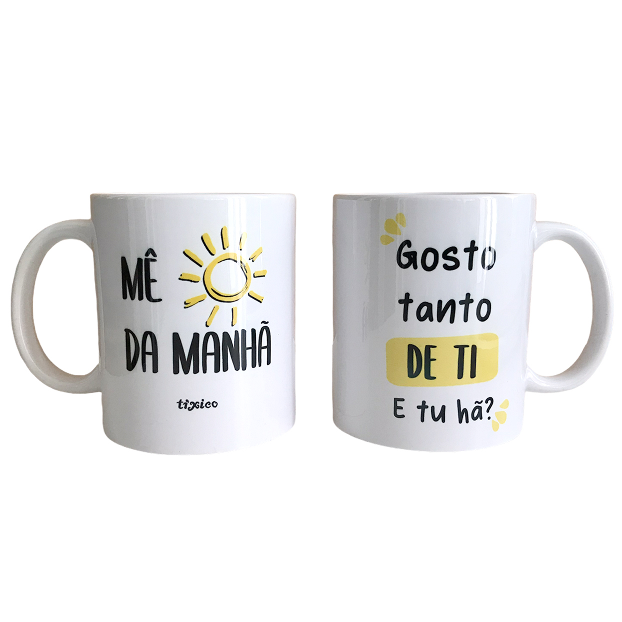 Caneca “Mê Sol da Manhã” Duas canecas brancas com frases em português e desenhos amarelos