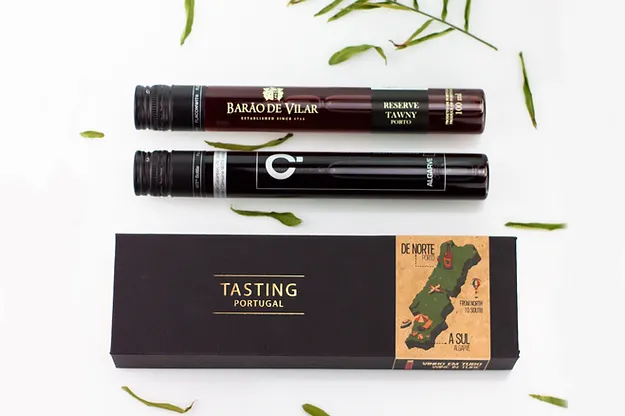 Dupla de Vinho - DE NORTE A SUL Duas garrafas de vinho em tubos e caixa preta com mapa e texto TASTING PORTUGAL