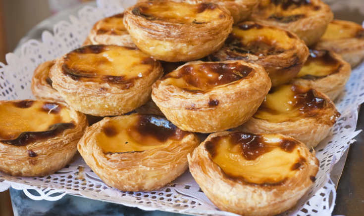 Pastéis de nata numa bandeja com papel rendado