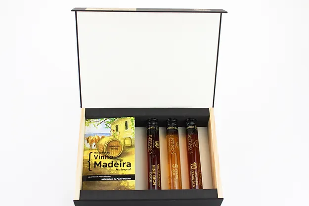 Bebendo a História do Vinho da Madeira Conjunto de tubos de vidro com líquidos castanhos numa caixa preta com folheto 'Vinho Madeira'