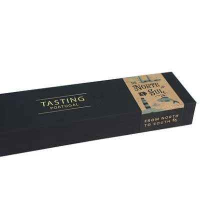 Caixa preta rectangular com inscrição TASTING PORTUGAL e faixa castanha DE NORTE A SUL