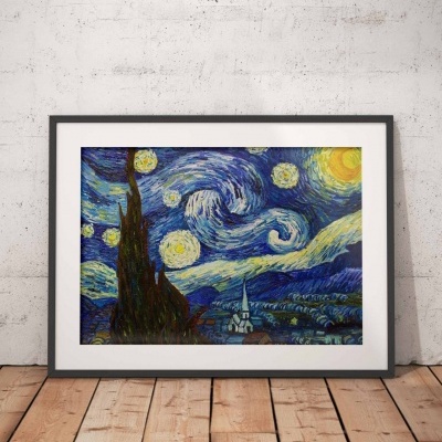 Quadro com reprodução da pintura A Noite Estrelada de Van Gogh em moldura preta, apoiado na parede