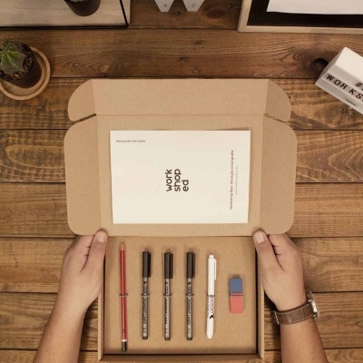 Conjunto de escrita numa caixa de cartão com várias canetas, borrachas e cartão WORK SHOP ed