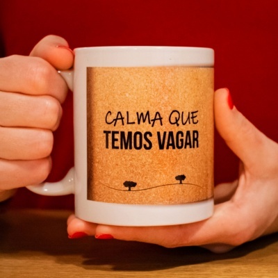 Caneca branca com base em cortiça e frase em português