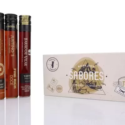 Três garrafas de vidro pequenas com líquidos coloridos e uma caixa branca ao lado