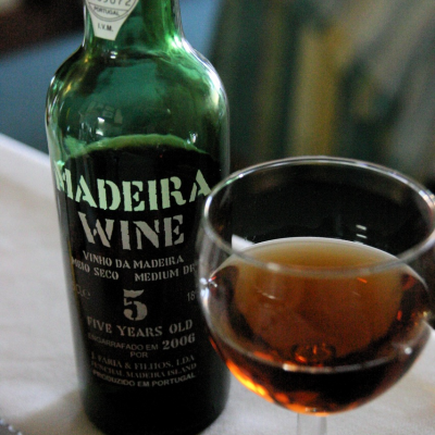 Garrafa de vinho Madeira e copo com vinho âmbar