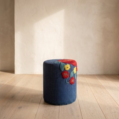 Pufe cilíndrico azul com bordados florais coloridos